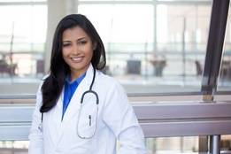 Smiling doctor standing near window in hospital