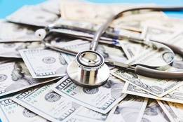 Stethoscope on top of pile of money