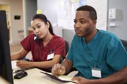 Two nurses working on computer in hospital